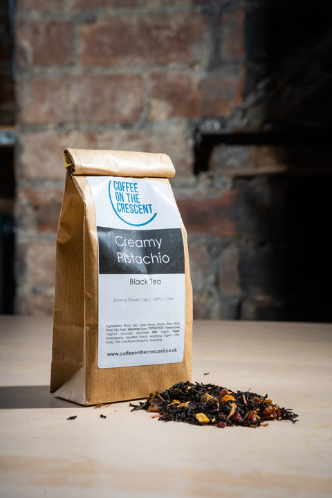 A retail bag agof Creamy Pistachio Tea with a sample of the leaves in front of the bag. 
